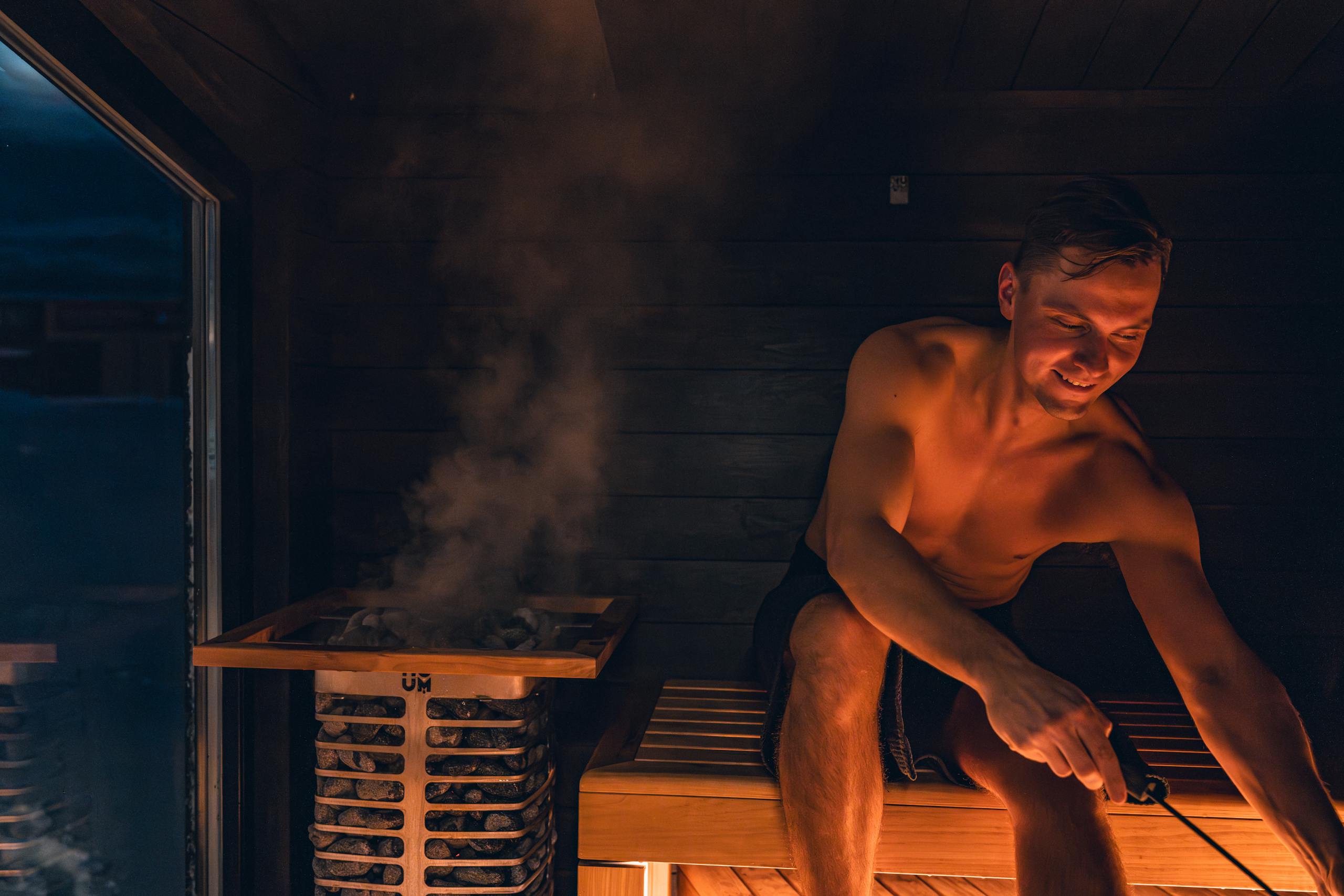 A man enjoying a warm and relaxing sauna session, embracing Nordic design.